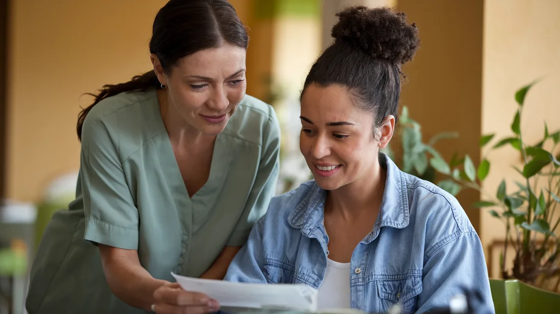 A case manager and a client reading through a plan on paper together.